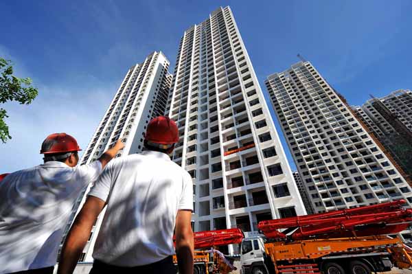 <p>Construction workers looking at buildings in China</p>